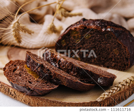 Black round bread on a cutting board Black round bread on a cutting board 111611716