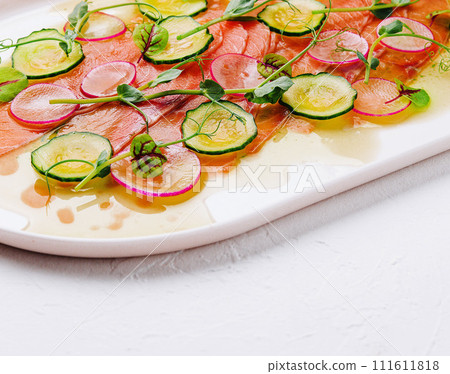 Buffet serving of pickled salmon slices with radish, cucumber 111611818