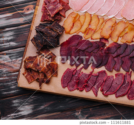 various jerky or dried meats and sausage on a board various jerky or dried meats and sausage on a board 111611881
