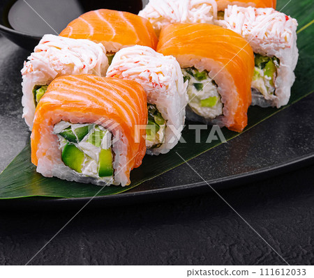 sushi rolls with salmon and crab on black plate sushi rolls with salmon and crab on black plate 111612033