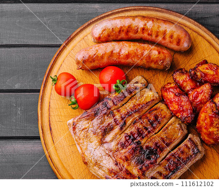 pork ribs with chicken and sausages on wooden board 111612102