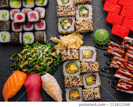 Large sushi set, shot from the top on a black background 111612166