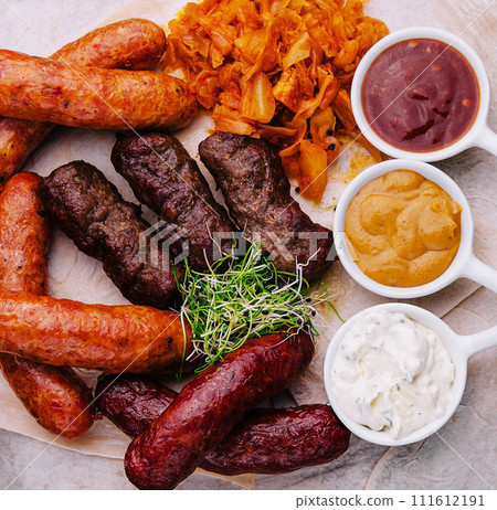 Beer set of grilled sausages with stewed cabbage and sauces Beer set of grilled sausages with stewed cabbage and sauces 111612191