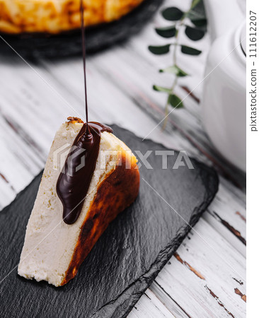 Pouring chocolate on delicious San Sebastian cheesecake Pouring chocolate on delicious San Sebastian cheesecake 111612207