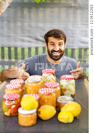 Happy man at table with natural foods and lemons, giving thumbs up Happy man at table with natural foods and lemons, giving thumbs up 111612265