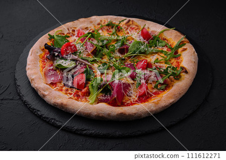 Italian pizza with prosciutto, arugula and cherry tomatoes 111612271