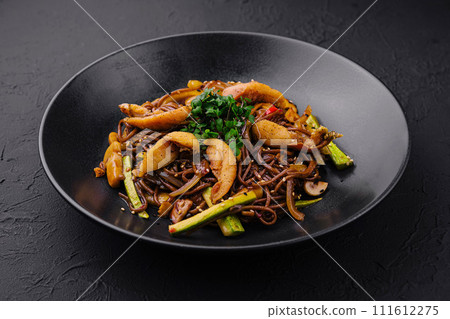 Chinese fried buckwheat pasta with meat on black plate Chinese fried buckwheat pasta with meat on black plate 111612275