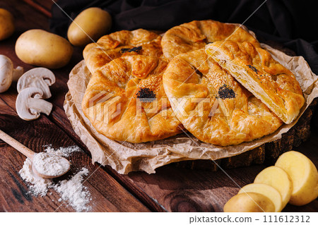 Cooking traditional pies with potato on wooden board Cooking traditional pies with potato on wooden board 111612312