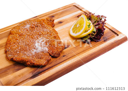 Schnitzel with salad on wooden tray Schnitzel with salad on wooden tray 111612313