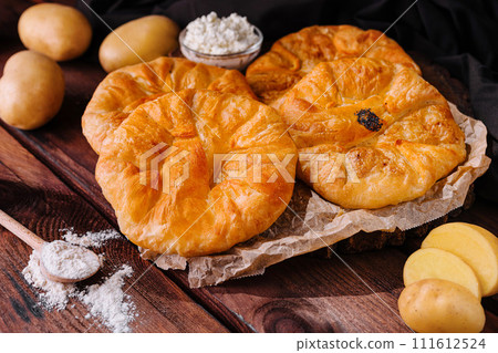 Cooking traditional pies with potato on wooden board Cooking traditional pies with potato on wooden board 111612524