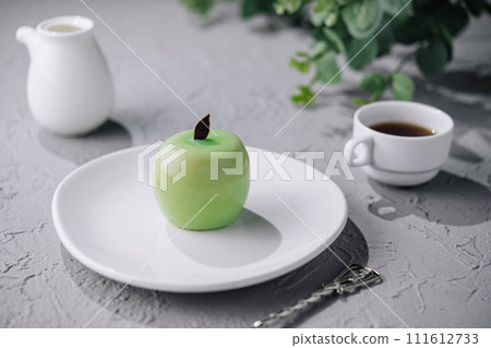 Green apple shaped mousse cake and cup of coffee 111612733