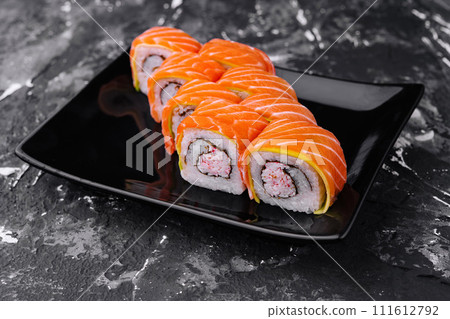 sushi rolls with salmon and crab on black plate sushi rolls with salmon and crab on black plate 111612792