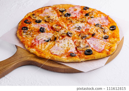 pizza with ham and mushrooms on a light background 111612815