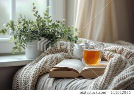 A minimalist reading nook with wellness books, herbal tea, and a cozy throw blanket for ultimate relaxation and self-care, focused books, a soft throw, and a calming, AI-generated 111612955
