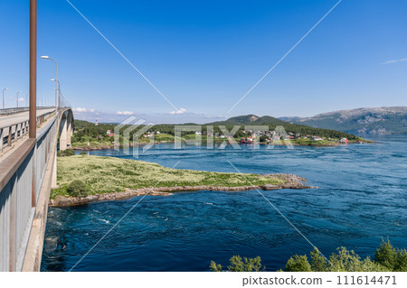 World's strongest maelstrom under Saltstraumen Bridge, picturesque village afar 111614471