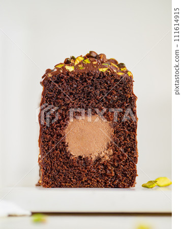Travel Cake or Tube Cake or Voyage Cake filled center tube ganache and topped chocolate icing and pistachio. Chocolate loaf cake with chocolate cream-cheese filled center. Copy space. Vertical Travel Cake or Tube Cake or Voyage Cake filled center tube ganache and topped chocolate icing and pistachio. Chocolate loaf cake with chocolate cream-cheese filled center. Copy space. Vertical 111614915