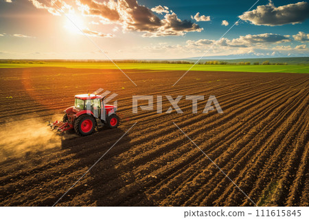 Panorama of a field with a tractor plowing the land on a farm, view of the fields and sunset taken by a drone, concept - Earth Hour and concern for the future harvest, seasonal work on the farm 111615845