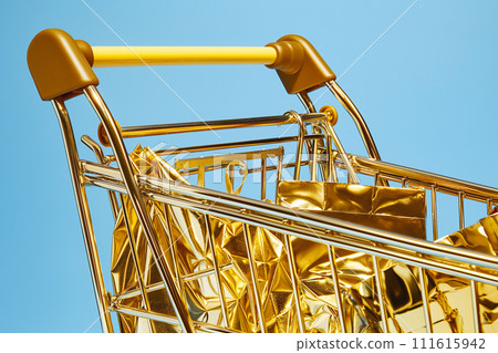 Shopping cart with bags. Golden shopping basket full of gold shopping bags on blue background. Sale, Black Friday concept, shopping season, purchase, discounts, shopaholic. Promotion, marketing Shopping cart with bags. Golden shopping basket full of gold shopping bags on blue background. Sale, Black Friday concept, shopping season, purchase, discounts, shopaholic. Promotion, marketing 111615942