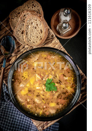 Pea soup with pieces of white sausage, potatoes and small dumplings. Pea soup with pieces of white sausage, potatoes and small dumplings. 111616109