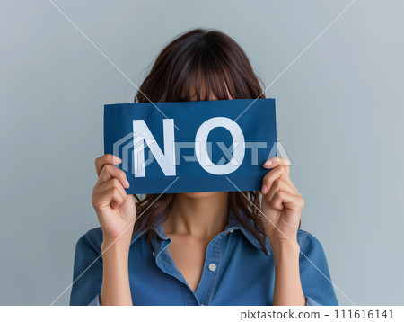 A woman holding a card that says "NO" 111616141