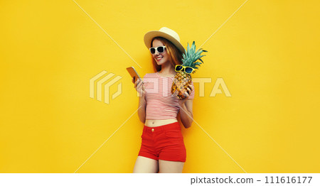 Summer portrait of traveler young woman with smartphone holding pineapple fruit 111616177