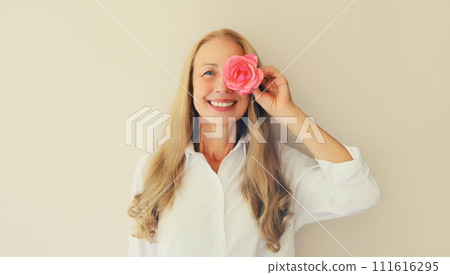 Summer portrait of caucasian happy smiling middle aged woman with pink rose flower buds Summer portrait of caucasian happy smiling middle aged woman with pink rose flower buds 111616295