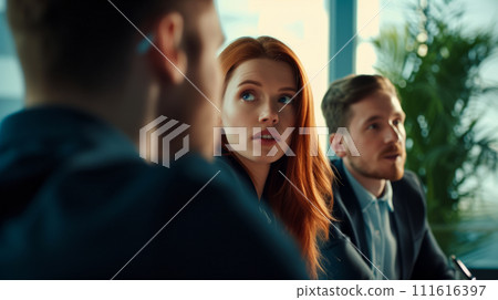 Portrait of a young red-haired woman manager at a meeting in the company office, company teamwork concept 111616397