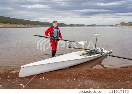 senior rower is rigging his rowing shell on a shore of Carter Lake in northern Colorado in winter scenery 111617173