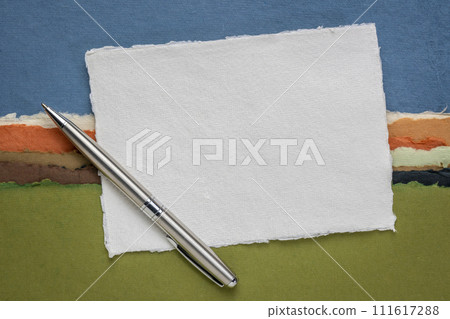 small sheet of blank white Khadi rag paper from India against abstract landscape with a pen small sheet of blank white Khadi rag paper from India against abstract landscape with a pen 111617288