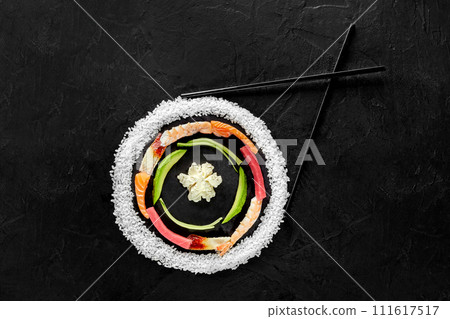 Layered colorful circle of raw sushi ingredients on black Layered colorful circle of raw sushi ingredients on black 111617517