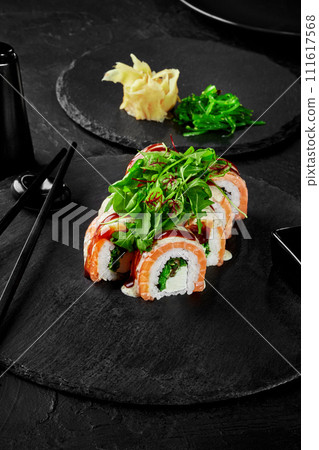 Sushi rolls with cream cheese, hiyashi wakame and salmon on slate board 111617568