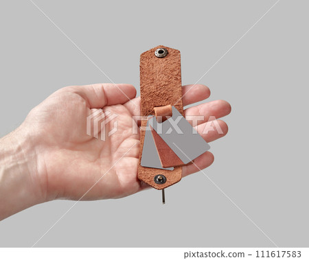 Bespoke brown leather key holder with printed family portrait in male hand Bespoke brown leather key holder with printed family portrait in male hand 111617583