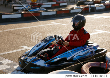 Diver racing on go-cart track outdoors enjoying competitive activity Diver racing on go-cart track outdoors enjoying competitive activity 111618311