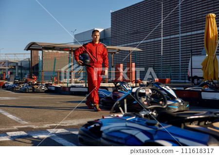 Go-kart driver walking to car before race at starting line Go-kart driver walking to car before race at starting line 111618317