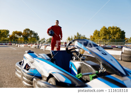 Go-kart driver walking to car before race at starting line 111618318