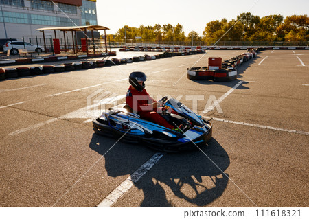 Karting pilot ready to start championship in outdoor go-karting circuit 111618321