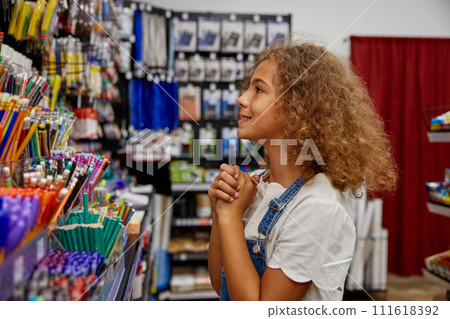 School girl choosing pen at stationery store preparing for new education year 111618392