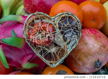 Golden heart shaped mesh case is filled with Dried fruits on Variety of assorted fruits. 111618718