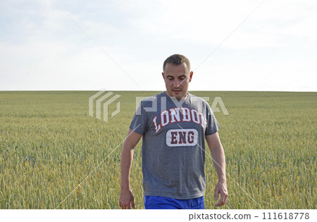 a male farmer stands among a field of ripening wheat harvest a male farmer stands among a field of ripening wheat harvest 111618778