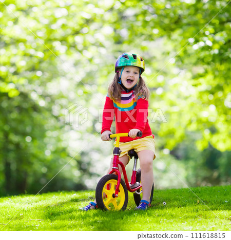 Kids ride balance bike in park 111618815