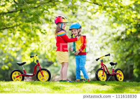 Kids ride balance bike in park 111618830