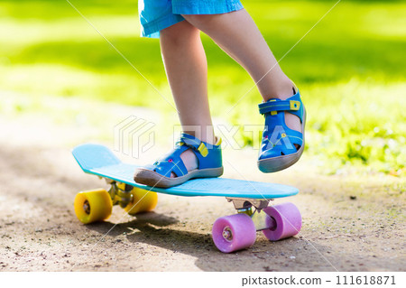 Child riding skateboard in summer park 111618871