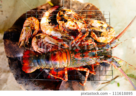 Seafood grill on the beach. Lobster and fish BBQ Seafood grill on the beach. Lobster and fish BBQ 111618895