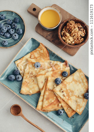Thin pancakes, homemade crepes on a plate with blueberry 111619173