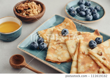 Thin pancakes, homemade crepes on a plate with blueberry 111619182