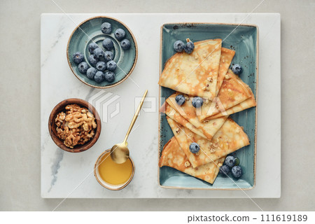 Thin pancakes, homemade crepes on a plate with blueberry 111619189