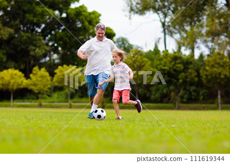Father and son play football. Dad and kid run. 111619344