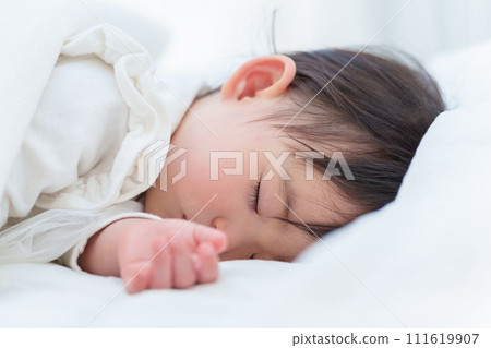 baby taking a nap in bed 111619907