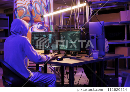 Hacker in hood gathering information using illegal spyware on computer to break into server. Criminal doing web tracking with malicious software and checking data on screen 111620314