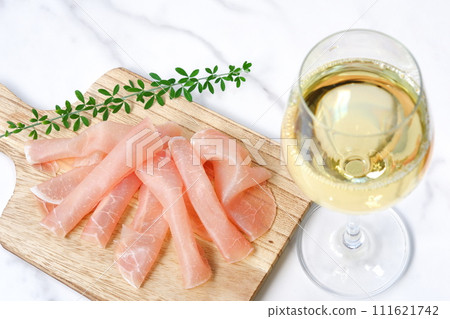 享用鹹鮮可口的生火腿當零食，喝乾白葡萄酒。 111621742